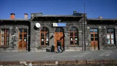 Akyaka tren istasyonu önden görünüyor, kapısından iki adam geçiyor. 2022