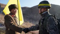 Iyi sanamu y'umusirikare wa Korea ya Ruguru n'uwa Korea y'Epfo baramukanya yerekanya ibibe bidasanzwe ku mpande zompi 