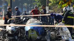 Equipes de emergência trabalham no local onde um pequeno avião caiu sobre veículos na Avenida Marquês de São Vicente, em São Paulo, Brasil, em 7 de fevereiro de 2025.