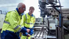 Un trabajador de mayor edad junto a uno joven.