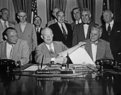 O presidente dos EUA, Dwight Eisenhower, segura o Projeto de Lei de Energia Atômica após sua assinatura na Casa Branca em 31 de agosto de 1954.