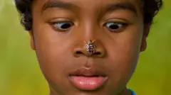 Menino com inseto no nariz