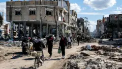 صورة تظهر فلسطينيين في أحد الأحياء المدمرة في قطاع غزة