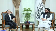 امیر خان متقی وزیر خارجه ایران در سمت راست با لباس افغانی و محمد رضا بهرامی در سمت چپ با دریشی 