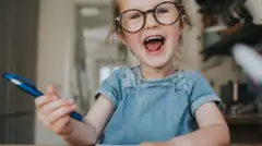 Menina segurando caneta