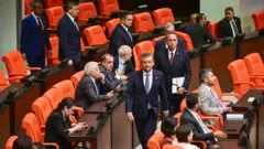 Özgür Özel Genel Kurul'da konuşma yapmak üzere kürsüye milletvekilleri arasından yürüyor (10 Ağustos 2026)