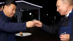 O presidente chinês, Xi Jinping, segura um prato enquanto ele e o presidente russo, Vladimir Putin, com um avental, brindam com copos pequenos