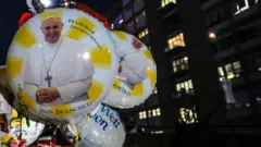 Homenagem de fiéis ao papa em um balão.