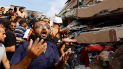 Palestinos vasculham os escombros de uma casa destruída pelos ataques israelenses em Khan Younis, no sul da Faixa de Gaza