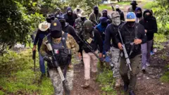Varios hombres con armas, equipo táctico y rostros cubiertos
