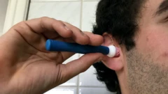 رجل يأخذ عينة من شمع أذنه