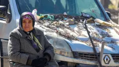 Woman by damaged van in Maras, Turkey