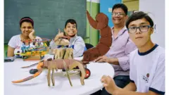 Julia, Guilherme e André exibem seus projetosbra betrobótica na salabra betrecursos com o professor Edson