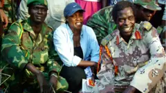 Betty Bigombe ari kumwe n'intumwa ya LRA mu biganiro Brig Sam Kolo (i buryo) mu 2004