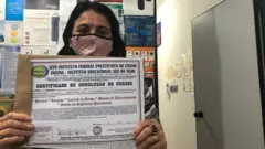 Soraya Ribeiro, 55, em certificado do curso de porteiro nas mãos