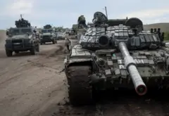 Xe quân sự Ukraine đi gần xe tăng Nga bị phá hủy ở thị trấn Izium