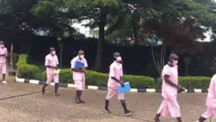 Rusesabagina (wa gatatu uvuye inyuma) hamwe n'abo bareganwa kuwa gatatu bajya mu rukiko