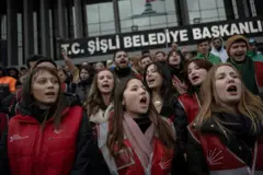Şişli Belediyesi binası önünde kalabalık, önde bir polis, arkada Türk bayrağı ve Atatürk'ün resmi