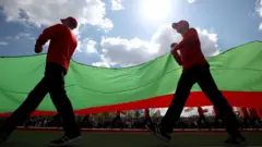 People carry a Belarus flag