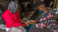 Des femmes préparent les ingrédients d'un repas à Harare, au Zimbabwe.