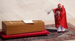 Cardinal Giovanni Battista Re, lasiko ti isin n lọ, fi omi mimọ ya posi Pope si mimọ. 