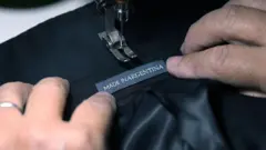 Um operário costura a etiqueta "Made in Argentina" em uma jaqueta na fábrica argentina Confecciones Seman S.A., em Buenos Aires, no dia 10 de fevereiro de 2026.