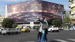 Dubartoonni lama boorsaa bittaa qabatanii Iraan keessatti poostara guddaa tokko bira darbu, daandii idilee tasgabbaa'aa konkolaattonni bira darban