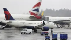 FILE PHOTO: Delta Airlines planes and a British Airways plane (2nd L) are pictured at Seattle-Tacoma International Airport,