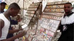 Vendeur et acheteur de CDs dans une rue de Kinshasa