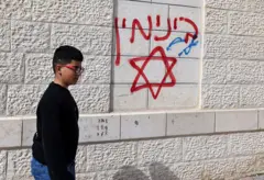 Un grafiti en una pared en Jalud que dice "venganza" y una estrella de david