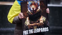 Ein Demonstrant in Polen fordert mit einem Schild die Entsendung deutscher Panzer in die Ukraine.