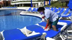 Trabajadora en piscina de hotel de Cancún