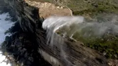 Waterfall flowing in reverse over cliff