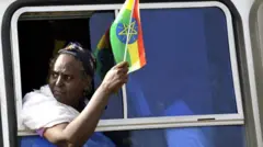 መንግሥት ካዘጋጀው የተቃውሞ ሰድልፍ የሚመለሱ ባንዲራ የያዙ ሴት  