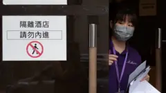 香港某隔離檢疫酒店一位女職員探頭察看街道上情況（30/10/2021）