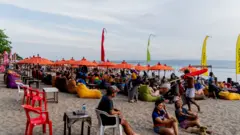 People hang out during evening hours at Seminyak Beach. Tourism in Indonesia is picking up after the covid 19 pandemic. The government has attempted to revive tourism by lowering or removing all entry requirements for foreign tourists