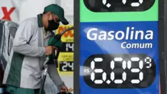 Posto de gasolina com cartaz anunciando combustível a R$ 6