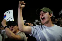 6일 서울의 한 개표소 앞에서 시위 참가자가 주먹을 들어 올리고 있다. 참가자들은 지방선거 과정에서 투표용지 부족으로 투표에 차질이 빚어진 데 항의하며 재선거를 요구했다.