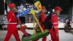 Trabalhadores da Pdvsa carregam um modelo de bomba de extração de petróleo