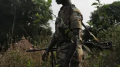 A Ugandan soldier stands in the bush on February 19, 2009 in Napopo, north eastern Congo