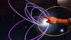 Mike Brown, professeur d'astronomie planétaire, pointe vers l'anneau en or montrant la trajectoire orbitale de la planète neuf à Caltec, le mardi 19 janvier 2016 à Pasadena, Californie