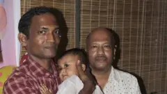 কার্টুনিস্ট আহমেদ কবির কিশোর (বাঁয়ে), কোলে শিশুকন্যা এবং ডানে বড় ভাই আহসান কবির (পারিবারিক ছবি)