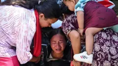 在尼泊爾努瓦闊特縣的巴塔爾巴扎鎮，一名女子在等待親屬抵達軍營之際崩潰痛哭。她此前已從受山洪暴發影響的地區獲救。（27/8/2026）