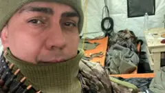 André Hack Bahi exibe munição em alojamento para combatentes da guerra na Ucrânia.