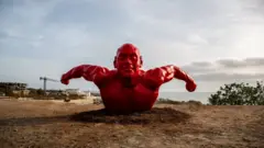 La sculpture d'un nageur rouge de Diadji Diop.