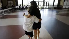شخصين يعانقان بعضهما