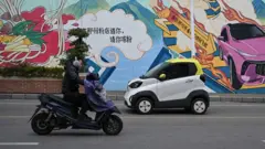 在中國南方城市柳州，街頭隨處可見色彩絢麗、身形小巧的微型電動汽車。