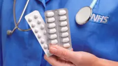 nurse holding tablets