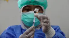 Mhudumu wa Afya wa Indonesiaakitayarisha dozi ya chanjo yaSinovac