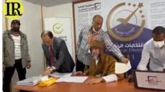 প্রেসিডেন্ট নির্বাচনের কাগজপত্র সই করছেন সাইফ আল-ইসলাম গাদ্দাফি